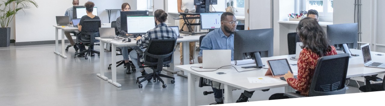 Wide angle shot of men and women at work in open work spaces